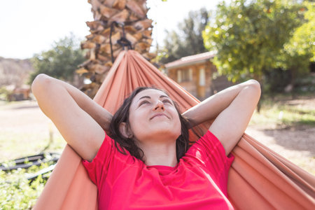 Portrait of a girl lying in a hammock, a woman resting in nature, traveling to beautiful places,...