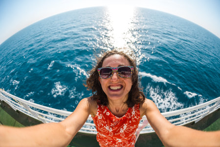 Woman with dark hair on the background of the sea, Portrait of a smiling woman on a background of the sea, emotional brunette.の写真素材