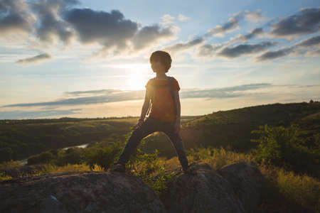 boy with a backpack on a hike. a hike with a child. summer vacation in nature.の写真素材