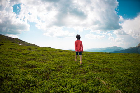 boy walks along a mountain path. rest at nature. children's camp.の写真素材