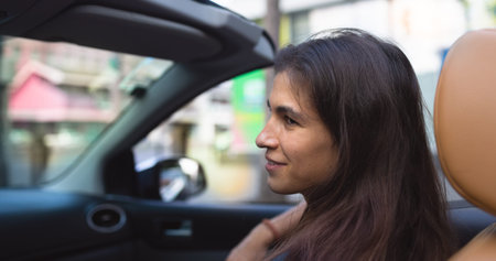 young beautiful girl rides in a convertible. passenger in a taxi. moving around the city by car.