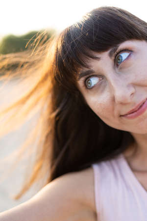 portrait of a young and beautiful girl with black hair at sunsetの写真素材