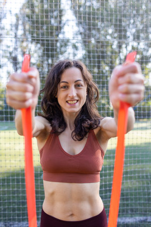 beautiful girl goes in for sports on the street. exercises with a gymnastic ribbon. beautiful body...