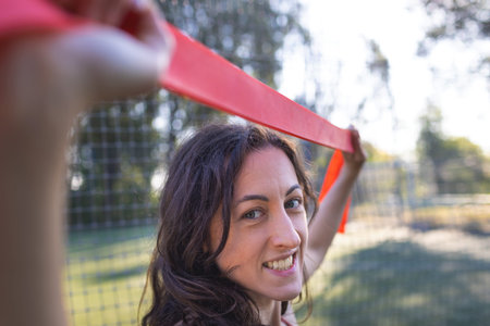 beautiful girl goes in for sports on the street. exercises with a gymnastic ribbon. beautiful body...
