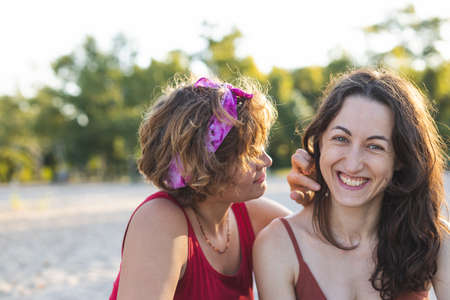Lesbian couple on the beach, portrait of two girls, lgbt community, relationship of two women, lovers, smiling girlsの写真素材