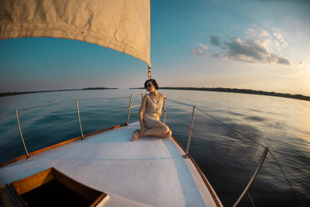 travel on a yacht. a young girl sits on the stern of a white yacht. privacy while traveling.の写真素材