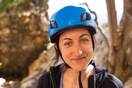Portrait of smiling woman in safety helmet, protective gear, rock climber in helmet, protection in extreme sportの写真素材