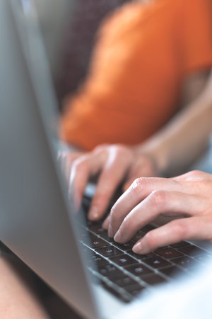 Female hands on the keyboard close up, the girl works at a laptop and types, the freelancer works at...