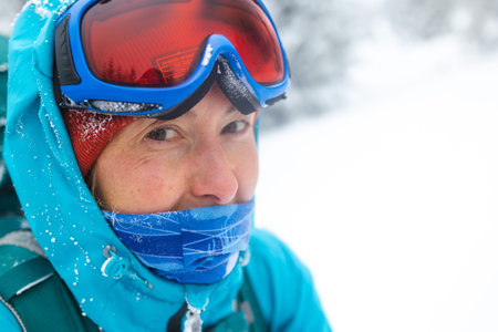 Portrait of climber in snowboard goggles, hiking, girl in winter trekking, woman in mountains in...
