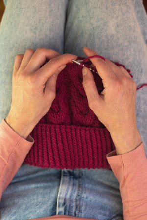 woman is knitting, female hands close-up, a woman is engaged in needleworkの写真素材