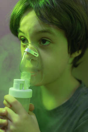 the child does inhalation, the boy inhales the medicine through the mask, nebulizer mask, treatment of the diseaseの写真素材