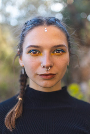 Portrait of a beautiful girl, a woman with a piercing in her nose, a girl with oriental makeupの写真素材
