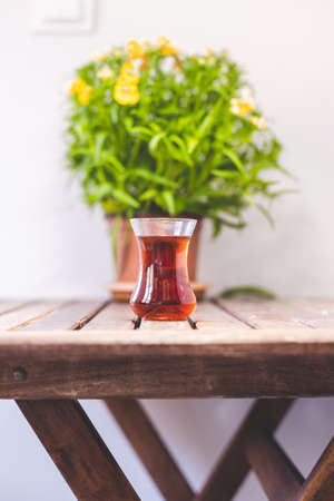 Glass of turkish tea on wooden table, potted plant and turkish traditional teaの写真素材