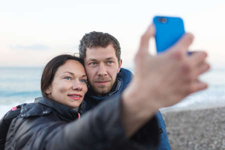 Lovers take a selfie near the sea, two people hug, man and a woman on the beach,の写真素材