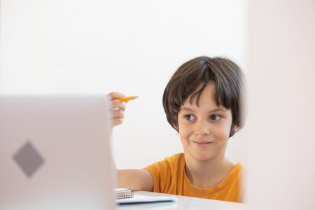 a boy gesturing with his hands during an online lesson. Online distance learning. a boy with a...