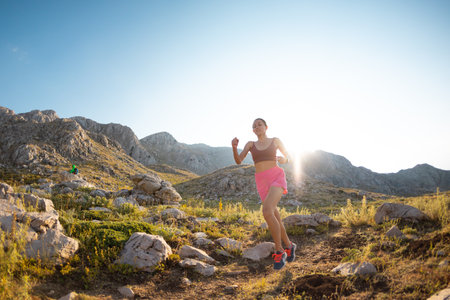 Woman runner runs through the beautiful mountains. running in the mountains. skyrunning.の写真素材
