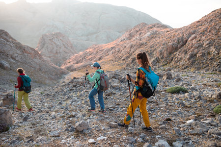 three tourists with backpacks in the mountains. Tourists travel through the rocky mountains. Active rest in mountain hiking. Adventure in the mountains. group hikesの写真素材
