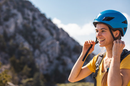 The girl puts on a helmet for mountaineering and climbing. Safety in extreme sports. outdoor sports. adventure and active lifestyle.の写真素材