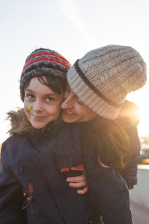 mom and son have fun and hug on the street while walking. portrait of a happy child next to mom.の写真素材