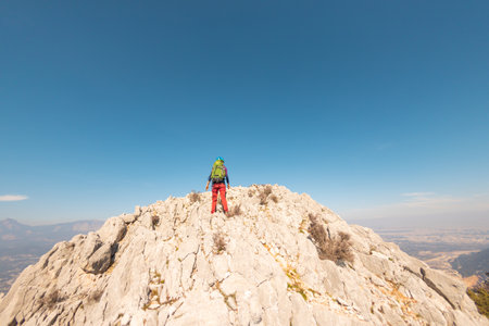hiking in the mountains. a girl with a backpack walks along a mountain range. climbing and hiking in the mountains.の写真素材