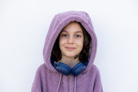 teenager in headphones and a purple hidi is standing on the street. Style boy. style and youth.