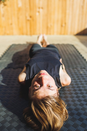 Close-up of an attractive young girl with short hair. lies on a yoga mat. yoga practice.の写真素材
