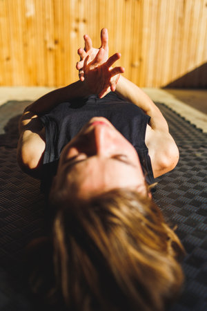 Close-up of an attractive young girl with short hair. lies on a yoga mat. yoga practice.の写真素材