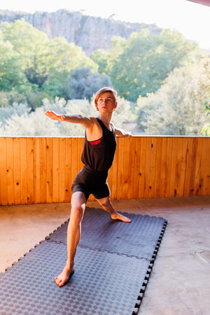 The girl is doing yoga. Young athletic woman trainer practicing yoga instructor individual training. pose, modern gym, balancing healthy lifestyle concept. sports in nature.の写真素材