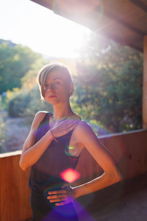 close-up. portrait of an attractive young girl with short hair and jewelry around her neck after yoga. yoga classes on the street. health and strength concept.の写真素材