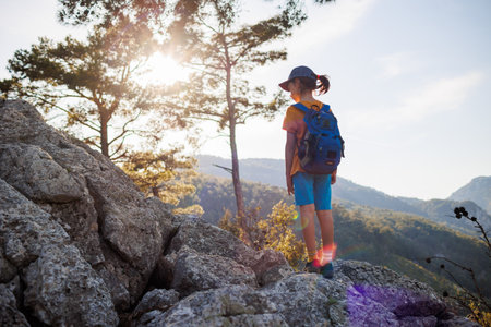 Adventure and travel. a little boy with a backpack walks along a forest path. trips with children. child in the forest.の写真素材