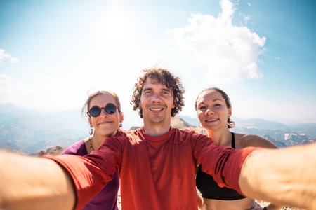 Photo of a group of friends taking a selfie. Smiling and happy people while traveling in the mountains. holidays and rest.の写真素材