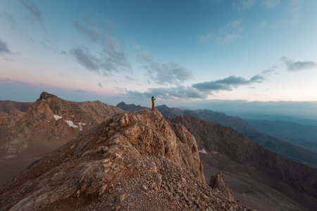 The girl is standing on top of the mountain. hiking in the mountains. mountain climberの写真素材