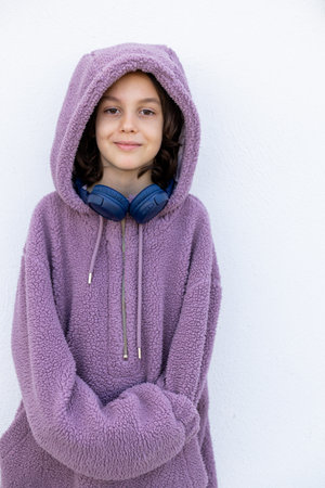 teenager in headphones and a purple hidi is standing on the street. Style boy. style and youth.の写真素材
