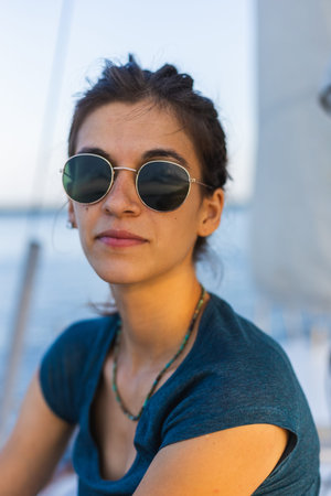 Portrait of a girl in sunglasses sitting on a yacht. vacation and travel concept