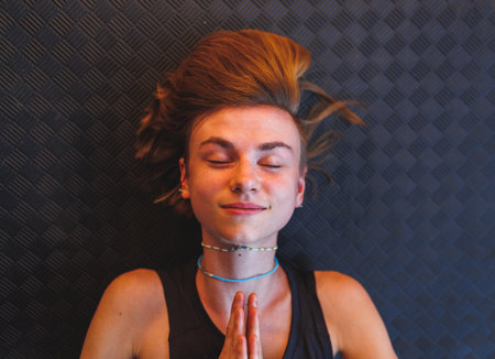Close-up of an attractive young girl with short hair. lies on a yoga mat. yoga practice.の写真素材