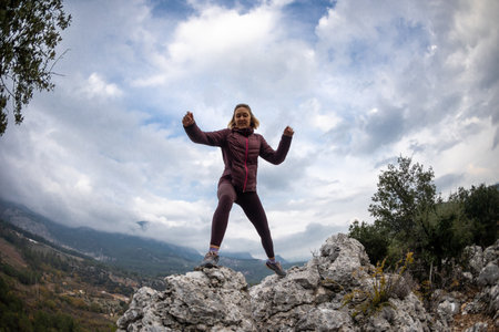 Successful female hiker hiking on a mountain peak. Travel and hiking concept.の写真素材