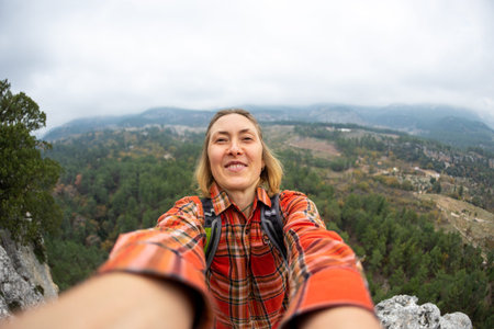 selfie of a woman on the background of a rocky and mountainous area. The girl smiles at the camera. tourism, holiday conceptの写真素材