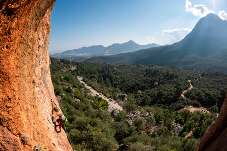The girl climbs the rock. Climber trains on natural terrain. extreme sport. Lessons on the street. A woman overcomes a difficult climbing route in Turkey. sports and adventure.の写真素材