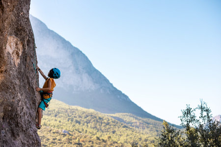 climber boy. the child trains in rock climbing. sports in nature.