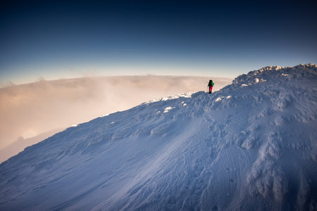 climbing a snow-covered mountain, two women in winter trekking, climbers climb to the top of the mountain in winterの写真素材