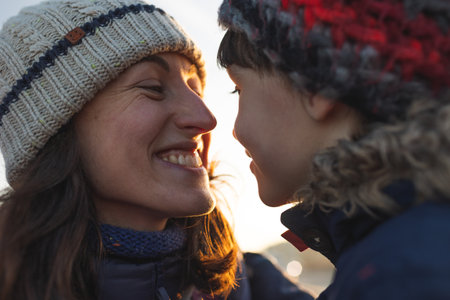 mom and son hug and look at each other. portrait of happy mother and son. winter walk along the street.の写真素材