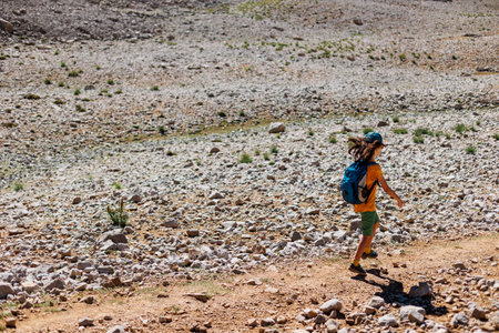 child travel in the mountains with a backpack. mountain hike in high mountains. the boy is walking along a mountain path. Turkey.の写真素材