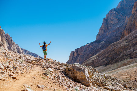 little boy with a backpack stands along the path against the backdrop of the mountains. travel and hikes. travel with children to the mountains. Turkey. Aladaglar.の写真素材