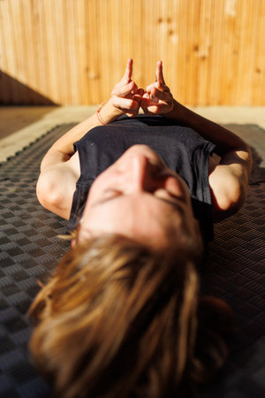 woman doing yoga on the street. Fit woman doing stretching exercises. hands close up. meditation and relaxationの写真素材