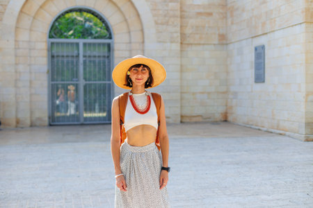 portrait of a young girl in a hat and beads. Fashionable accessories. the model looks at the camera and smiles.の写真素材