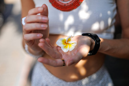 young girl holds a white flower in her palm. A model poses with a flower in her clothes. Health, motherhood and pregnancy concept.の写真素材