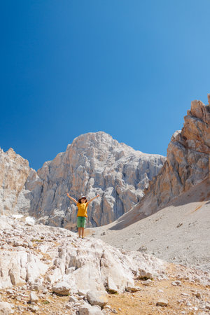 little boy with a backpack stands along the path against the backdrop of the mountains. travel and hikes. travel with children to the mountains. Turkey. Aladaglar.の写真素材