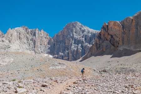 child travel in the mountains with a backpack. mountain hike in high mountains. the boy is walking along a mountain path. Turkey.の写真素材
