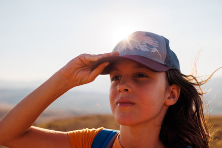 Travel to the mountains. portrait of a child in a cap. travel and hiking in the mountains. the boy puts on a cap on the street.の写真素材