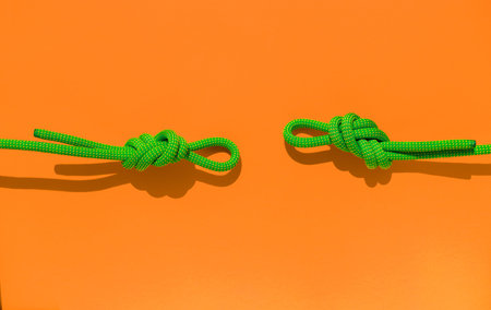 two ropes with secure knots. climbing rope with a knot lies on a colored background. concept of...
